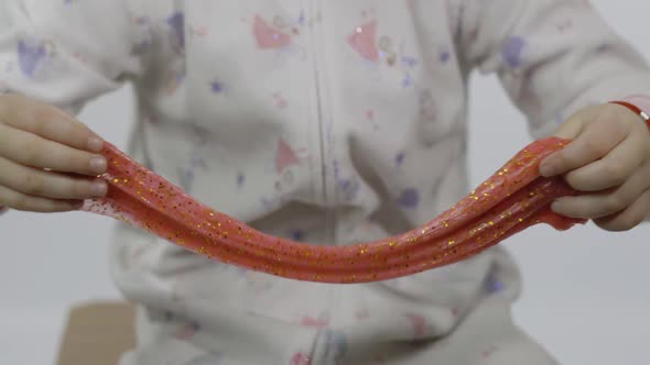 Kid Playing with Hand Made Toy Slime. Child Having Fun Making Red Slime