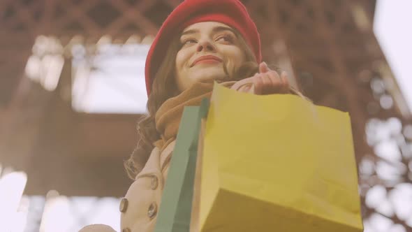 Happy brunette girl holding purchases, looking for mall, successful shopping