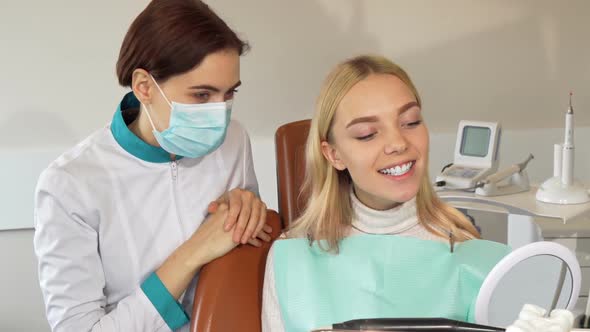 Professional Dentist and Her Patient Smiling To the Camera