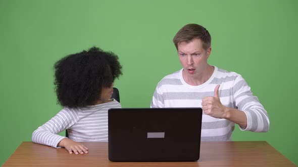 Young African Girl and Young Scandinavian Man Using Laptop Together