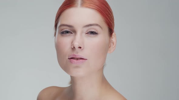 Studio portrait of young, beautiful and natural redhead woman. Beauty concept.