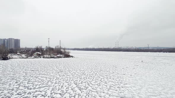 Flying Over a Frozen River with a City on the Bank