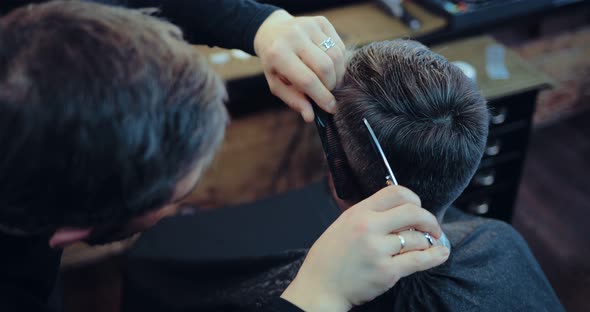 Professional Hairdresser Does a Haircut to a Man in the Salon