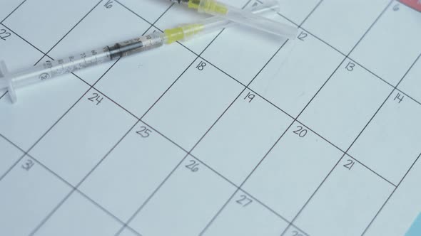 Two Syringes and Monthly Calendar