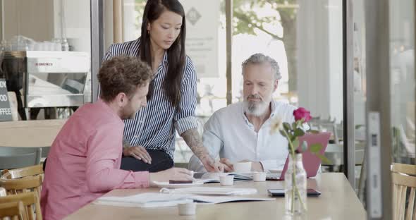 Three business partners having a meeting at a cafe