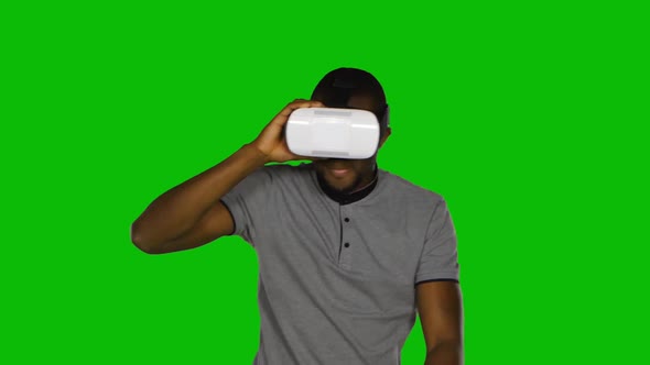 Man Holds a Mask of Virtual Reality on His Head. Green Screen