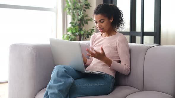 An Attractive Young AfricanAmerican Woman Using a Laptop at Home