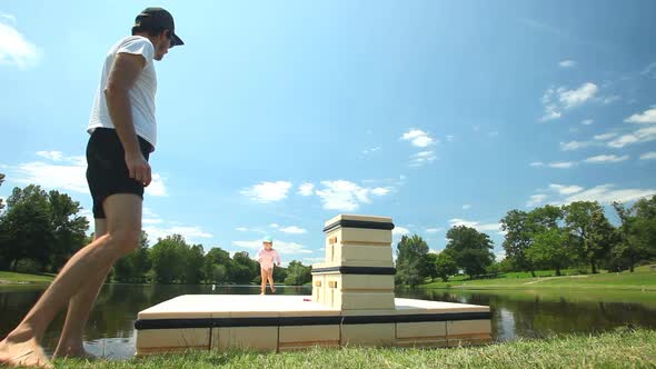 Father playing with daughter on floating platform on lake in France