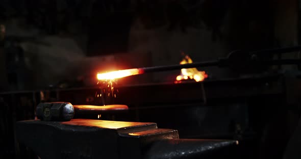 Mid-section of blacksmith working on a iron rod