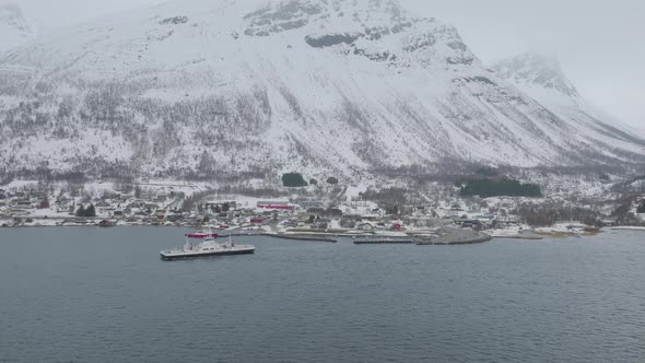 Kåfjord town centre and harbour at the foot of a mountain in Olderdalen, Norway. Overcast winter wea