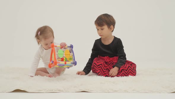 Toddler Girl Wearing Diaper and Her Sister Playing with Balls