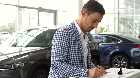 An Attentive Buyer Signs a Contract for the Purchase of a Car