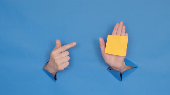 hand gestures through holes on a blue background with space for text