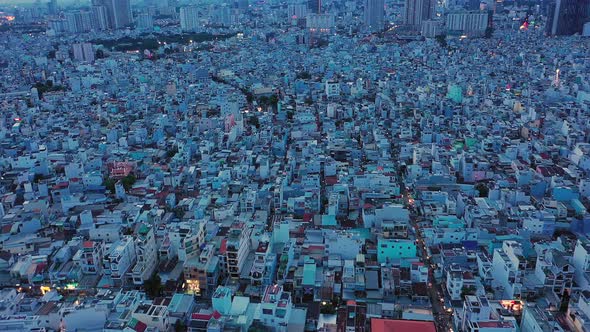 drone shot flying straight ahead at twilight over densely populated and built up area of a modern as