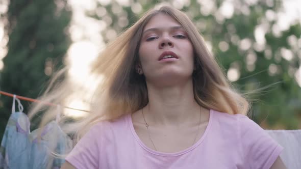 Front View Young Woman Shaking Clean White Cloth in Slow Motion Covering Camera