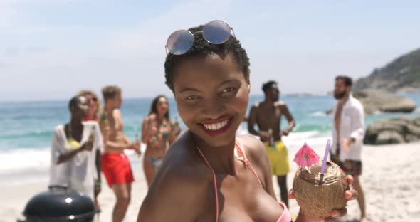 Front view of African American woman giving flying kiss and dancing on the beach 4k