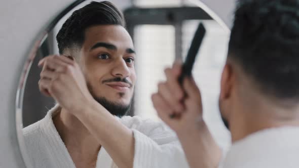 Arabian Spaniard Arab Man Looking at Mirror Combing Hair with Hairbrush Getting Ready in Bathroom