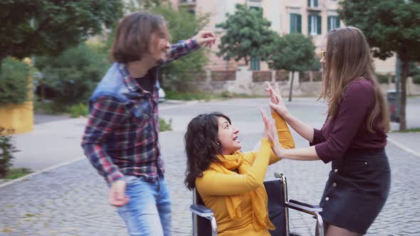 fun in wheelchair - woman with disability enjoys dancing with her friends