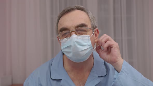 Close Up Portrait Elderly Man Takes Off a Medical Mask His Face