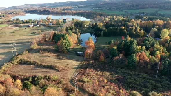 Aerial Drone Shot Flying Towards Power Lines and Farm with Pond and Fall Colors
