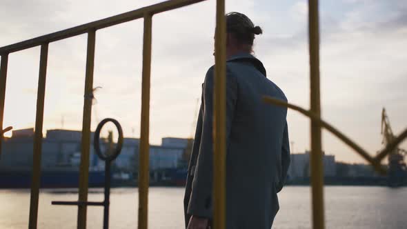 Young Stylish Handsome Redhead Hipster Man Walking on Sea Port Background During Sunset