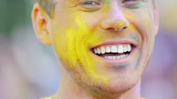 Young Male Face in Color Powder Smiling Close Up, Having Fun at Holi Festival