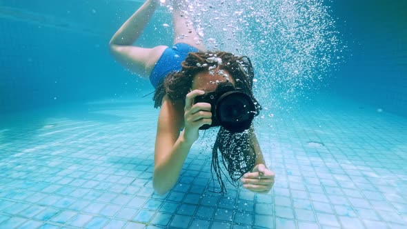 Travelling Girl in Asia. Happy Young Woman with Beautiful Long Hair Swim Under Water with Camera in