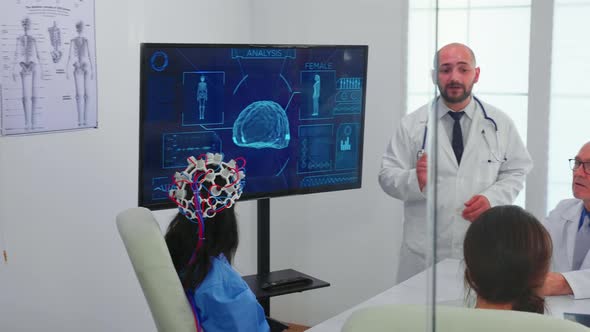 Doctor Talking About Brain Activity During Conference with Medical Staff