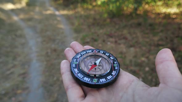 Female Forwarder Hands Holding a Compass and Looking for Direction