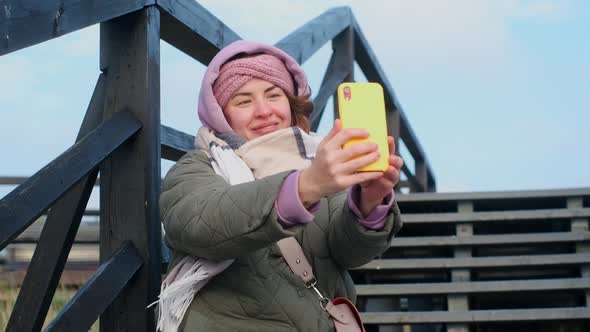 Blogger Woman in Warm Clothes Records Selfie Video By Her Phone