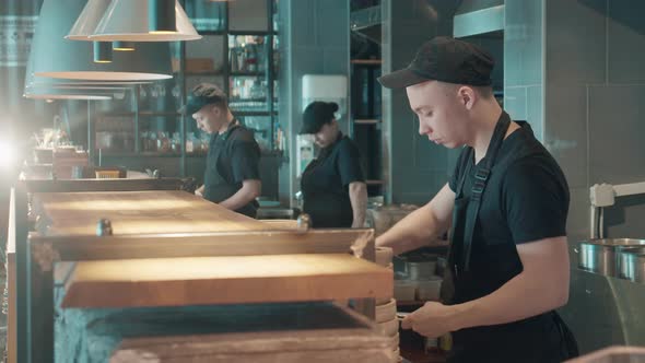 Team of Cooks Behind the Counter in the Restaurant