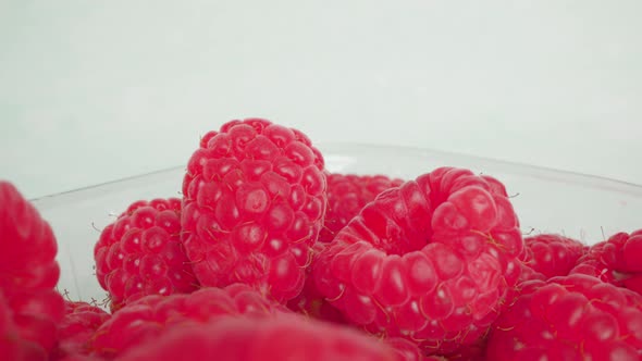 Raspberry Lies in Transparent Container on White Background