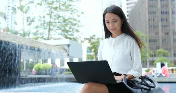 Business woman use of laptop computer in city