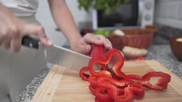 Girl Slicing Red Bell Pepper On Chopping Board