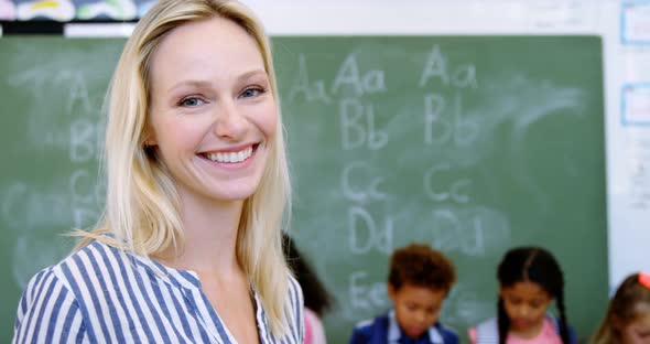 Portrait of happy teacher in classroom