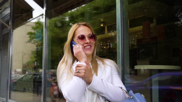 Happy Blonde Married Woman Talking on her Smartphone on Street