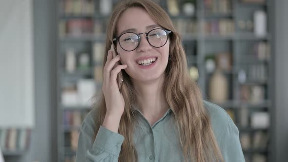 Portrait of Young Woman Talking on Smartphone in Office