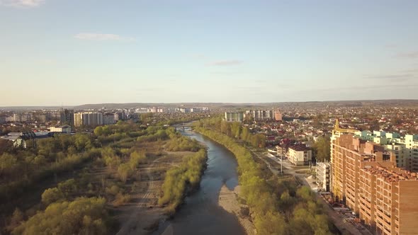 Aerial view of Ivano-Frankivsk city, Ukraine with Bystrytsia river and tall residential buildings 