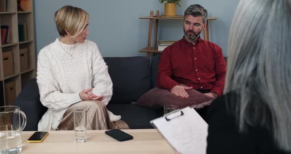 Man and Woman Sitting on Sofa at Female Psychologists
