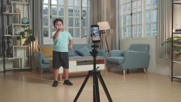 Asian Little Boy Dancing While Shooting Video Content For Social Networks With A Smartphone Camera alt