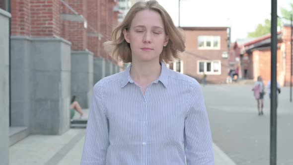 Woman Walking in Street While Looking at Camera