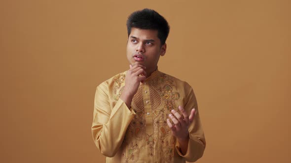 Positive Indian man in national cloth counting on fingers