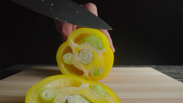 Hands of Man with Knife Slicing Yellow Sweet Pepper Into Rings