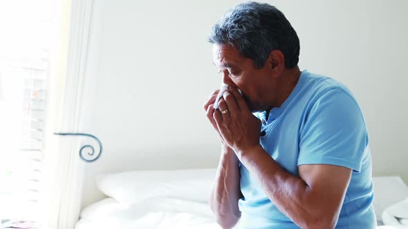 Senior man using a tissue to blow his nose 4k