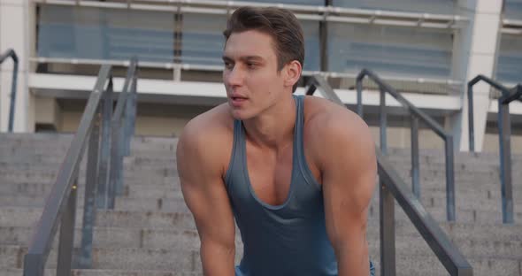 Athletic Sporty Man Relaxing After Run Outdoors on Stadium