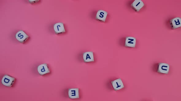 Rotating Cubes or Blocks Word with Letters Randomly on a Pink Background the Concept of a Newborn