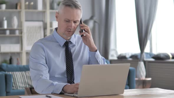 Gray Hair Businessman Discussing Project While Talking on Phone