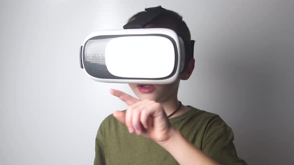 Boy use virtual reality headset helmet on white background. Virtual reality glasses. VR box
