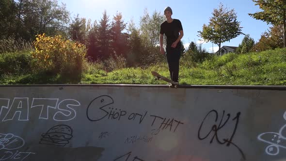 A young skateboarder skating in the bowl of a skate park.