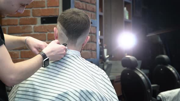 Hairdresser Makes a Haircut Design on the Back of the Client's Head